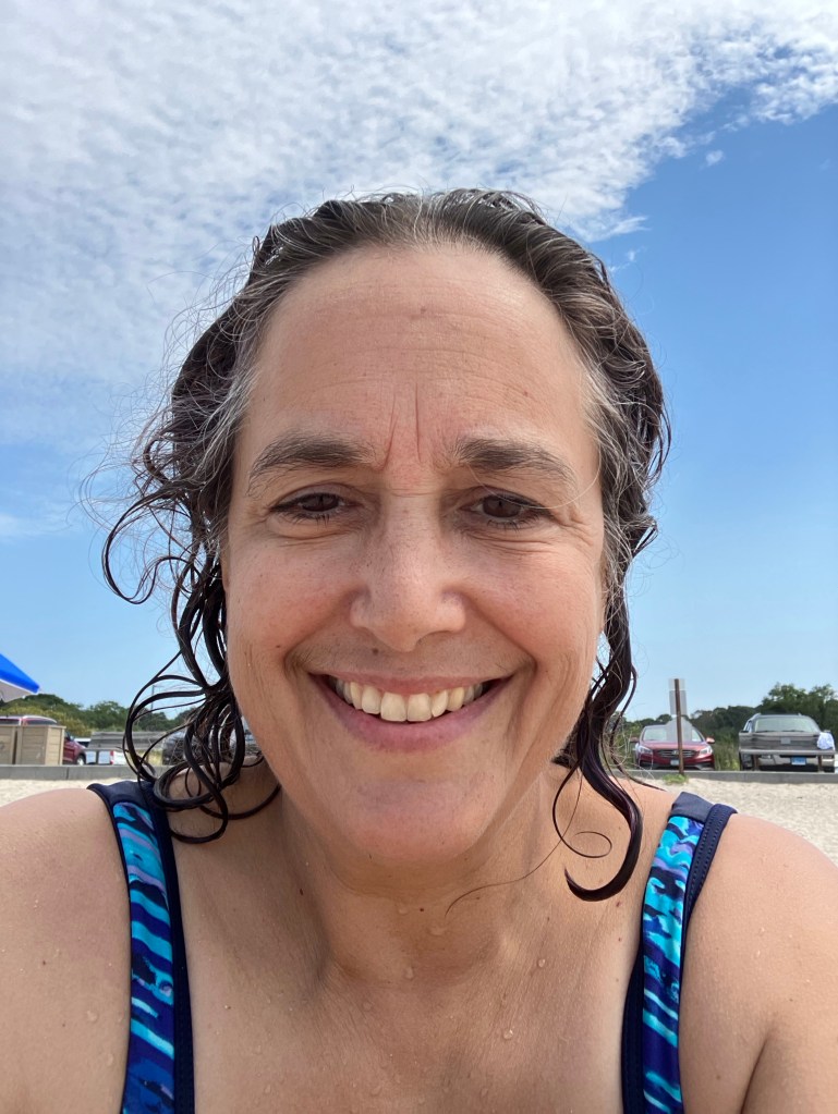 Fiber artist, Sarah Batchelder, smiling at the beach.