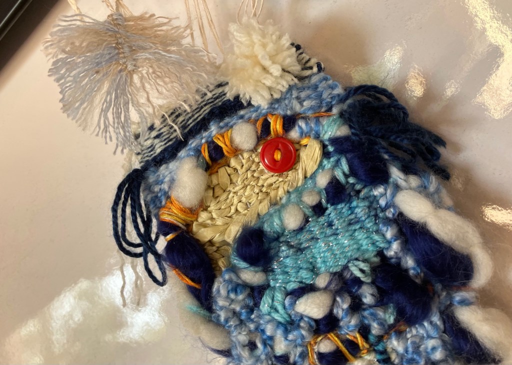 A closer image of the top of a hand woven mini tapestry by fiber artist Sarah Batchelder.